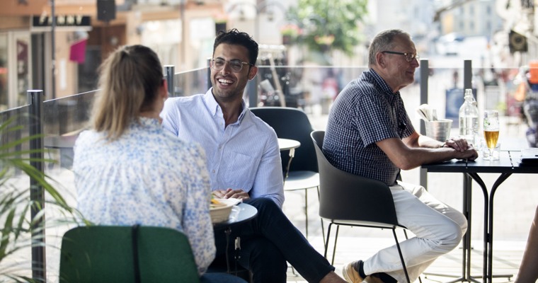 två personer sitter vid ett bord på en uteservering