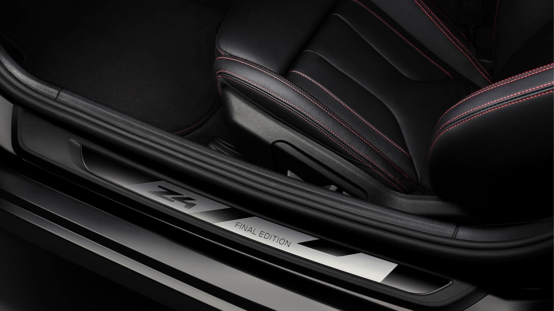 Närbild på BMW Z4 Final Edition instegslist och röd kontrastsöm på lädersäte