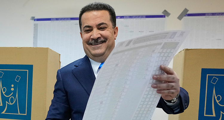 En glad man håller i ett stort papper.