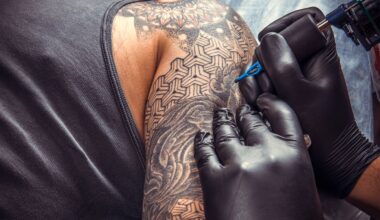 Man får armen tatuerad. Två händer med svarta handskar tatuerar med nål.