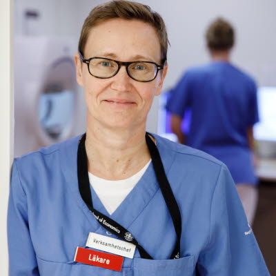 Chefen för ögonkliniken Susanne Lagergren Gross lutar ena axeln mot en vägg, ler och tittar in i kameran.