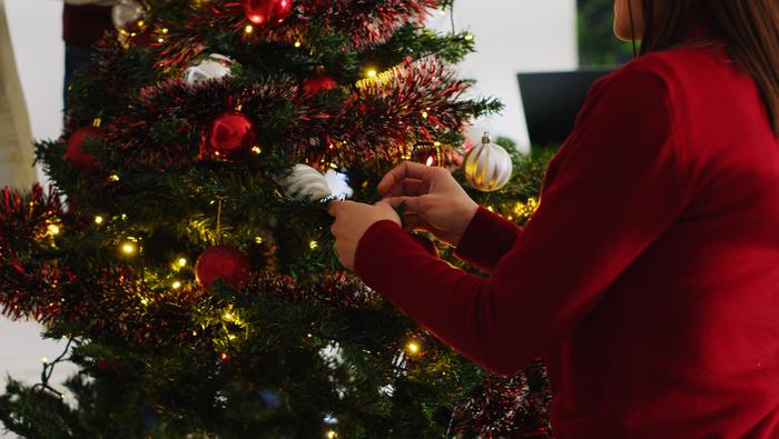 Person pyntar en julgran