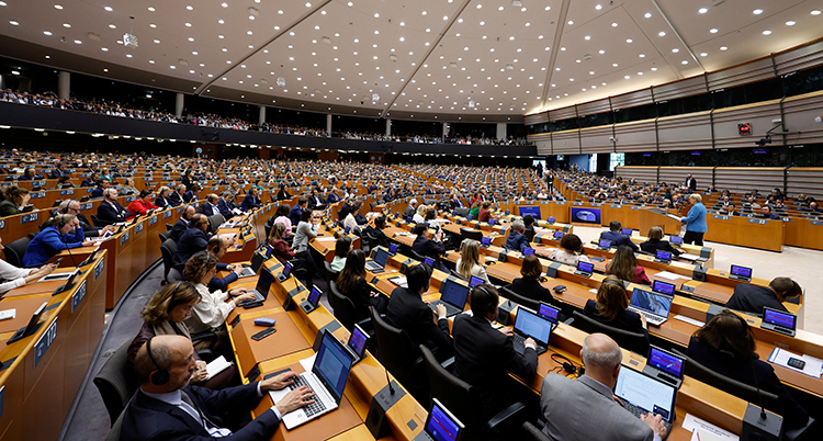 En stor sal där flera hundra politiker sitter i bänkar.