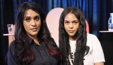 Två kvinnor med långt hår. De står bredvid varandra och tittar in i kameran.