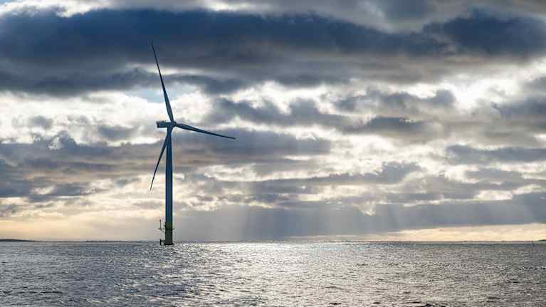 Ett vindkraftverk sticker upp ur havet.