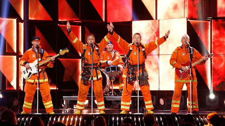 Ett band utklädda i brandmansuniformer.