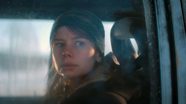 Närbild på en kvinna som tittar ut genom ett bilfönster.