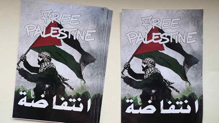 Bild på klistermärken med en ritad man med palestinas flagga i handen. På bilden står "Free Palestine". Även ordet "intifada" skrivet på arabiska.