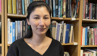 Kvinna framför en bokhylla.