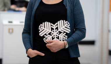 person som håller i ett vitt östersundshjärta, som är som en snöflinga format som ett hjärta