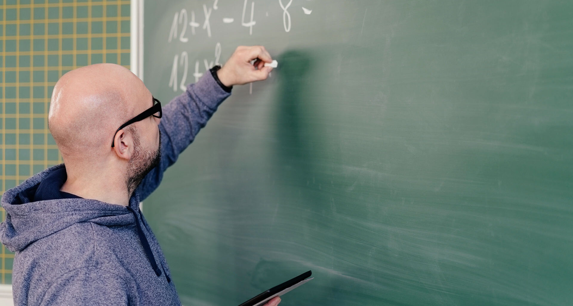 Lärare skriver tal på tavla.