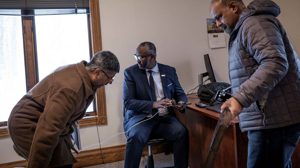 Jaylani Hussein (mitten) håller i ett möte för att se hur moskéns medlemmar ska ta sig vidare efter branden. Hans mobil ringer oavbrutet när DN talar med honom.