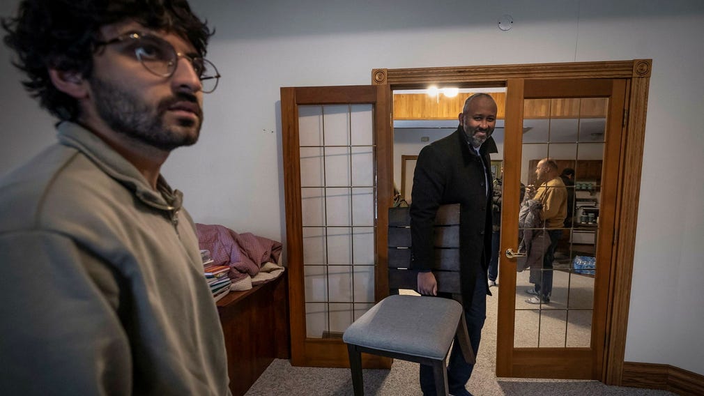 Alyan Olia (tv) gifte sig i moskén som brann ner i Prior Lake och hans fru jobbar där som lärare. Till höger bär Jaylani Hussein stolar till ett möte.