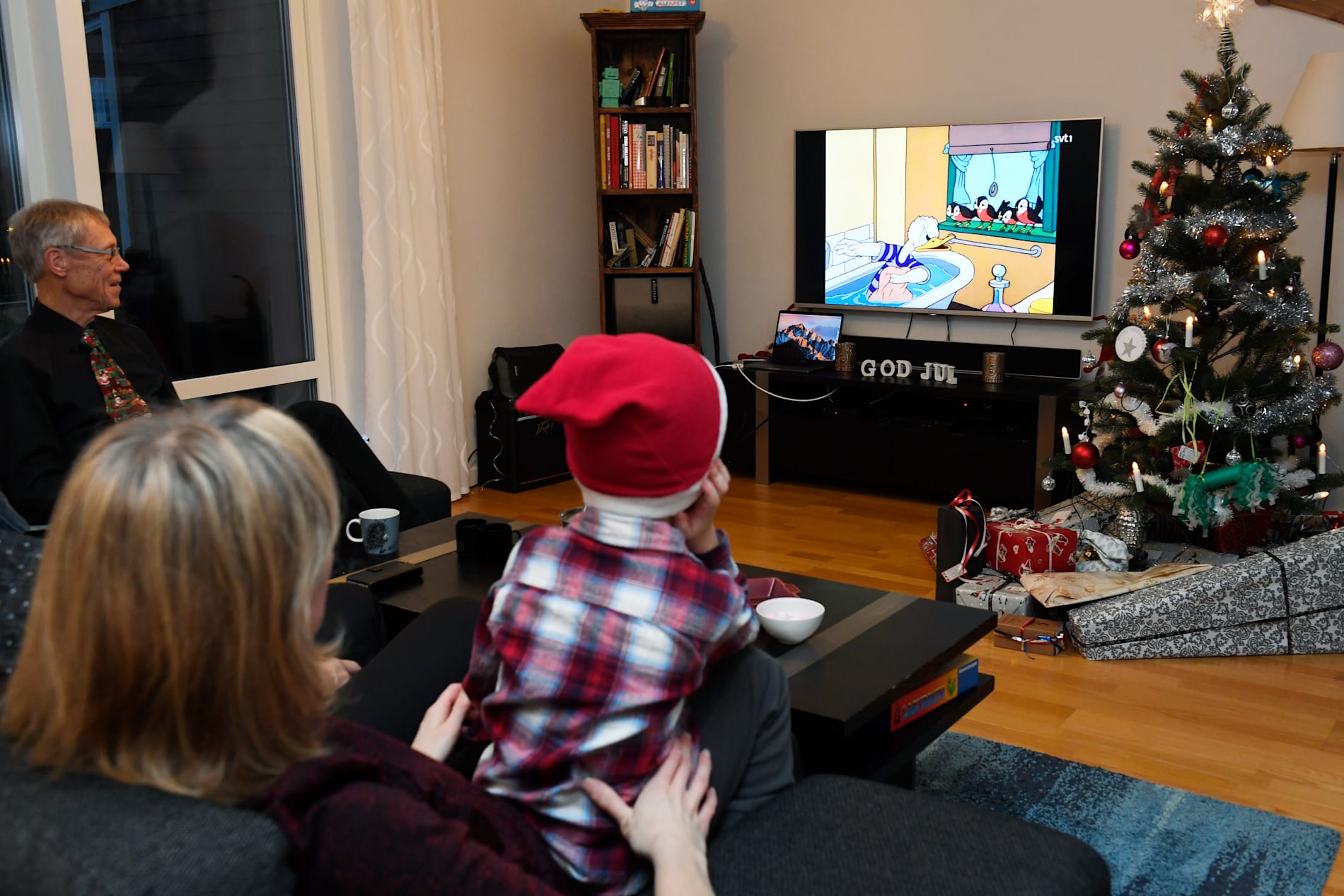 En familj tittar på "Kalle Anka och hans vänner önskar god jul" som traditionsenligt sänds kl 15.00 på julafton.