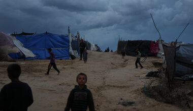 Barn leker utanför tält.