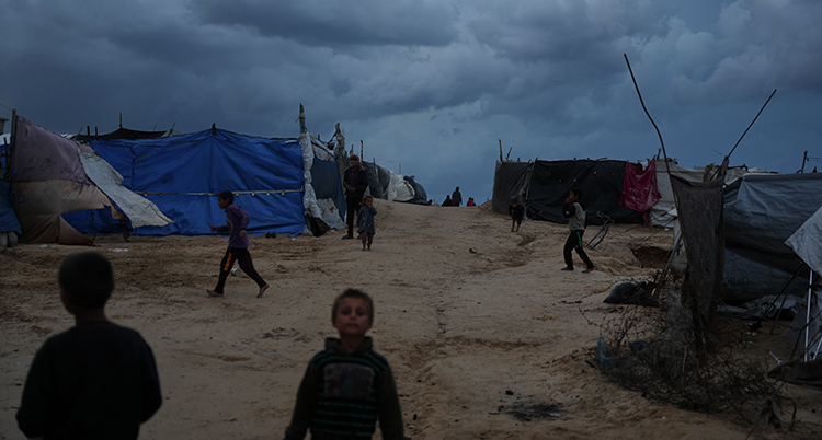 Barn leker utanför tält.