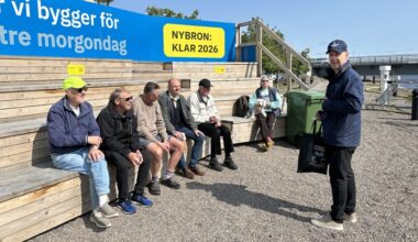 en person står framför en träläktare där det sitter sex personer.