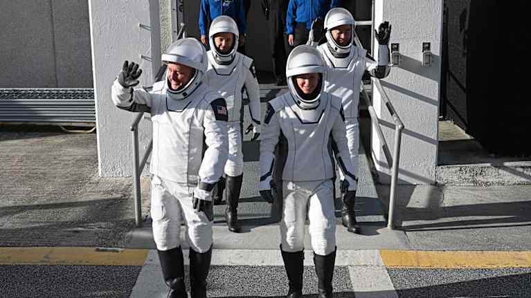 Astronauterna Mike Fincke, Oleg Platonov, Zena Cardman och Kimiya Yui i rymddräkter vinkar till fotograferna. 