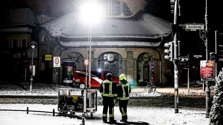 Två män från räddningspersonal vid en generator. 