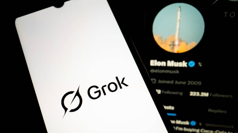 En mobiltelefon med texten "Grok". I bakgrunden finns Elon Musks X-profil.
