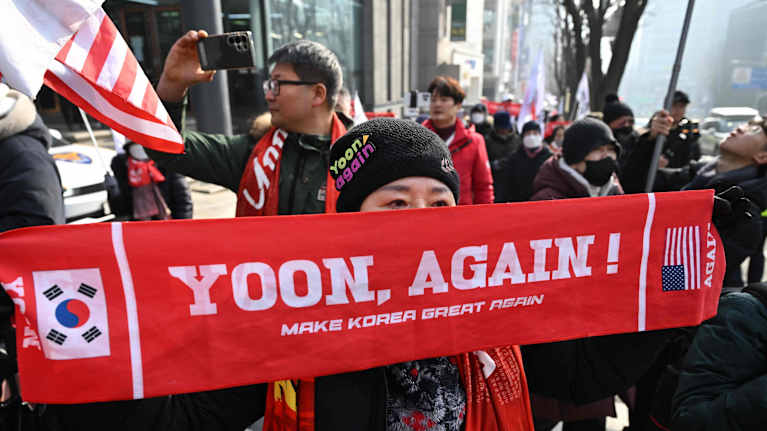Sydkorean håller upp en röd flagga till stöd för den avsatte presidenten Yoon Suk-yeol.