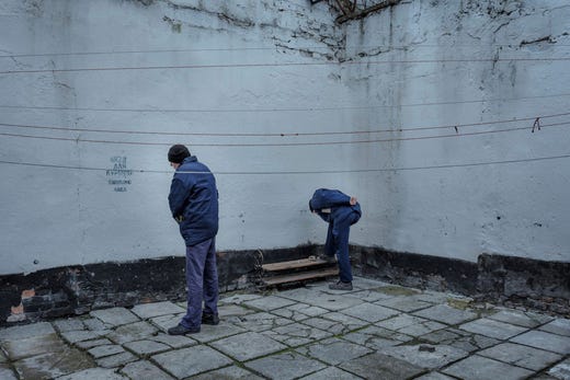 Några fångar putsar sina skor. Alla har utrustats med nya skor då de har anlänt till lägret.