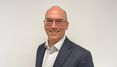 Porträttbild på Björn Hylenius iklädd vit skjorta, kavaj och glasögon.