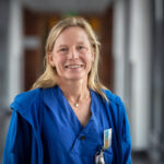 En porträttbild på en kvinna i vårdkläder.