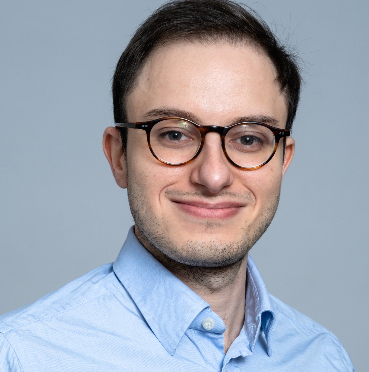 Porträtt av man i blå skjorta.