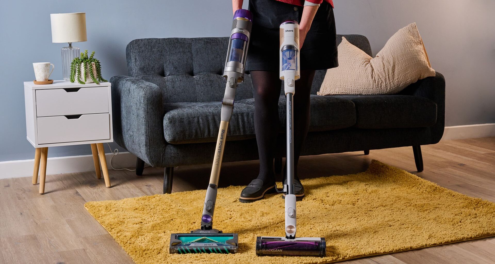 Person som h&aring;ller i den sladdl&ouml;sa dammsugaren Shark PowerDetect och den sladdl&ouml;sa dammsugaren Shark Detect Pro.