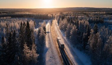 Lastbil som kör i ett vinterlandskap.