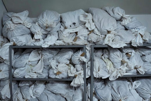 De här säckarna innehåller fångarnas kläder, som de hade på sig när de kom till lägret. Ofta är de smutsiga, blodiga och trasiga. Varje säck är försedd med en namnlapp.