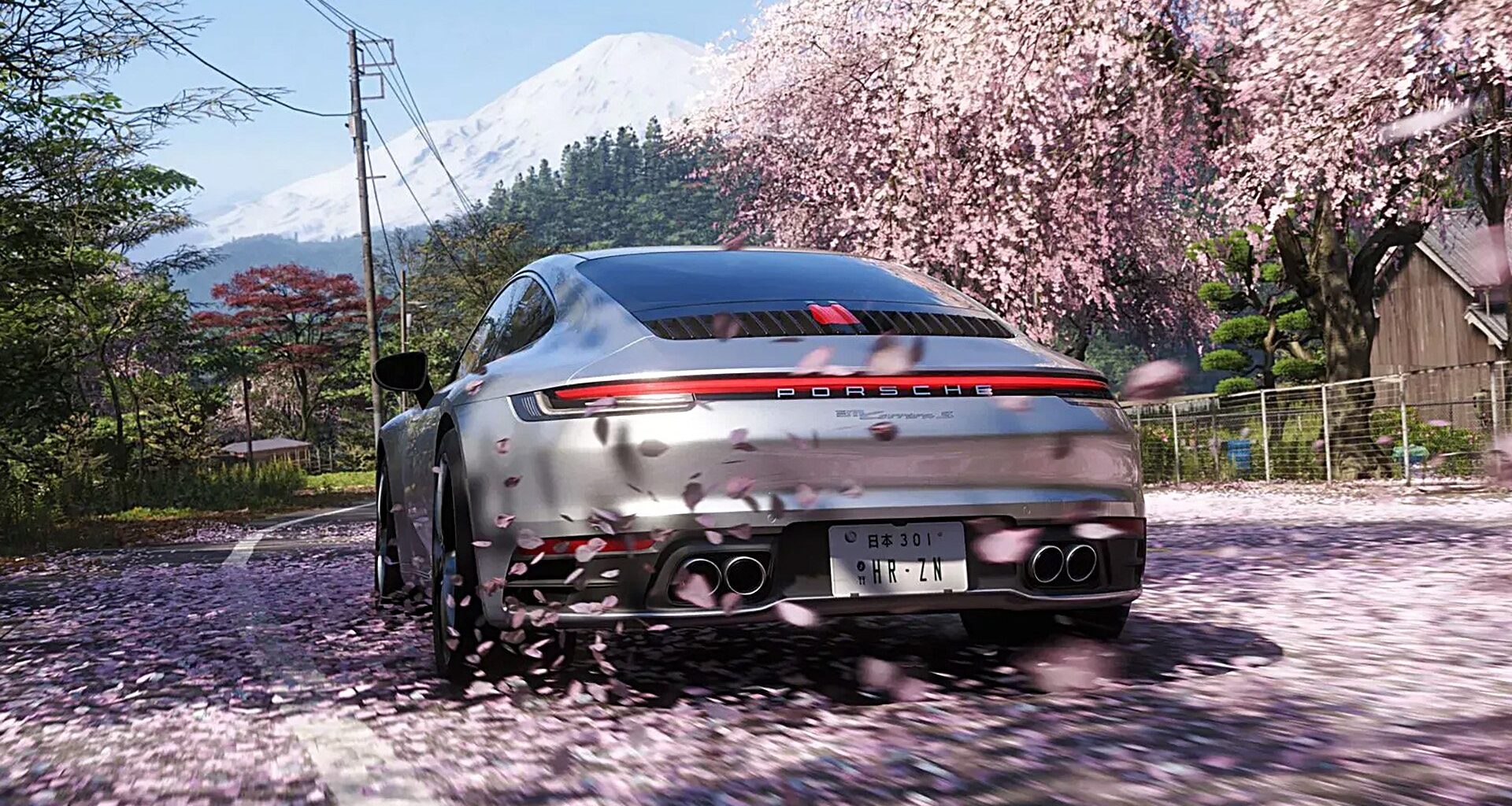 Porsche 911 bland blommande körsbärsträd och med Mount Fuji i bakgrunden.