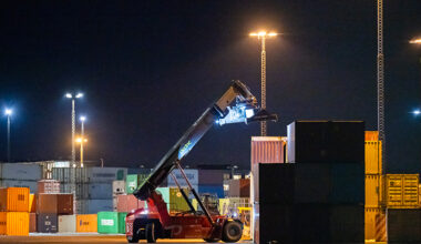 En truck kör i hamnen. Det är kväll.