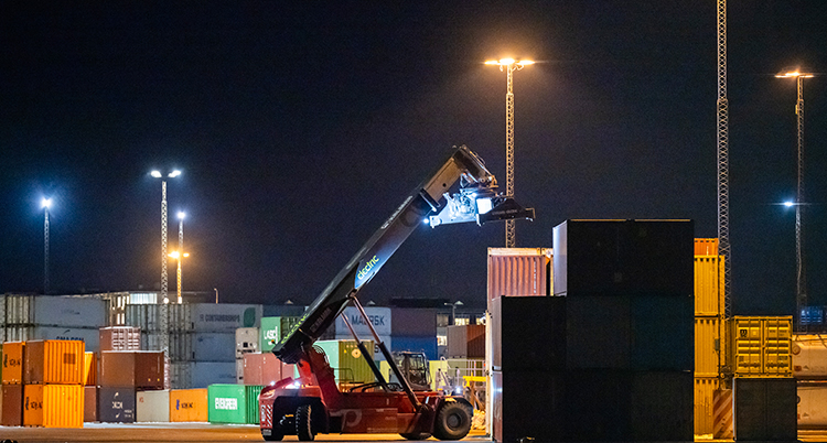 En truck kör i hamnen. Det är kväll.