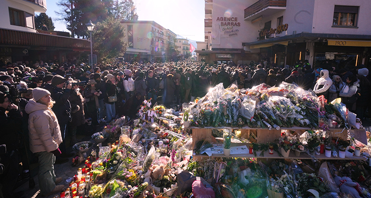 Människor runt ett berg av blommor.