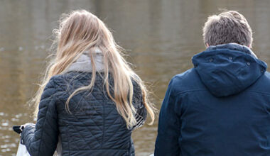 Tjej och kille sitter vid havet.