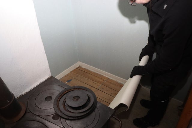 Linnea Ringius river bort plastmattan och finner ett vackert trägolv därunder.