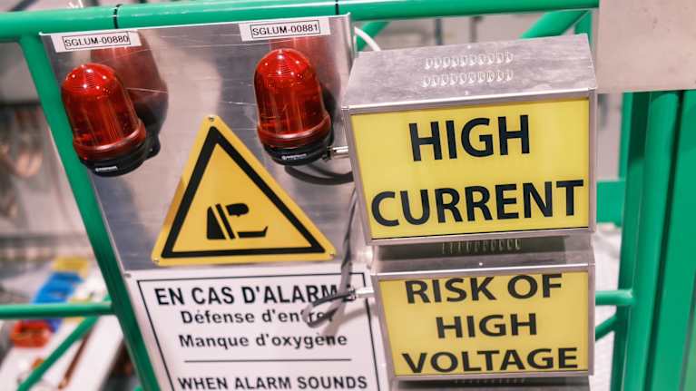 En apparat med varningsljus och varningstexter som varnar för extra hård spänning och risk för farliga gaser.