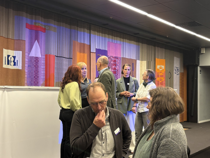 Personer diskuterar livligt vid en scen
