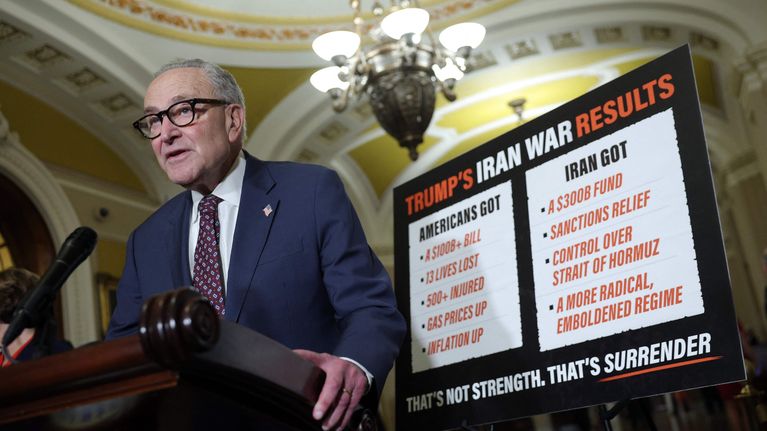 Minoritetsledaren i USA:s senat, Chuck Schumer talar framför en tavla där man listat upp vad USA fått och vad Iran fått genom kriget.