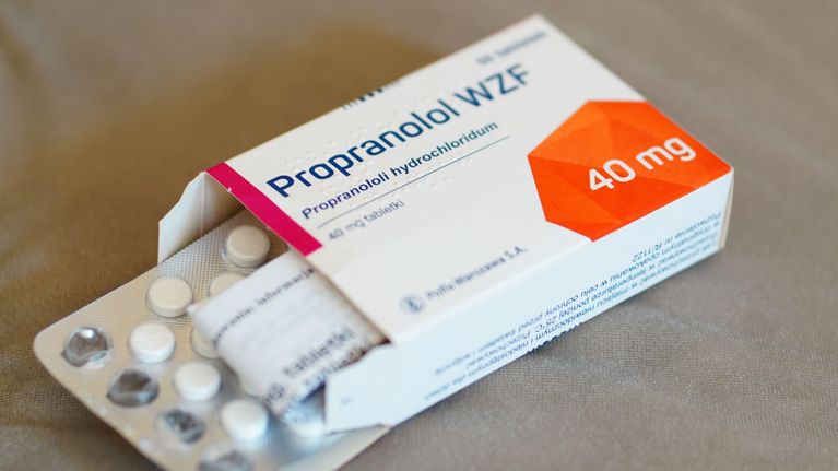Ett paket med mediciner mot en beige bakgrund. På paketet står det "Propranolol 40 mg". Paketet är öppet och en pillerkarta syns inne i lådan.