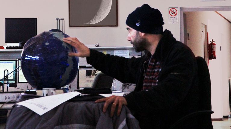 Porträtt på en astronom som tittar på en glob.