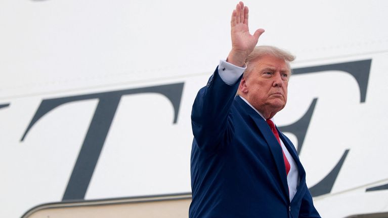 Donald Trump vinkar när han är på väg in i ett flygplan.