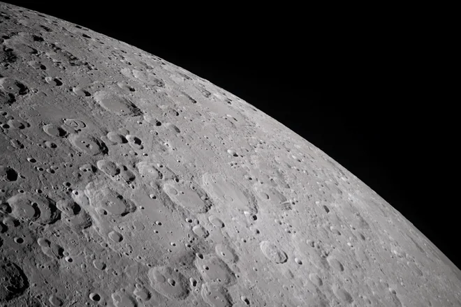 Na fotografiji, ki jo je posnela posadka misije Artemis II, so vidni kraterji, ki prekrivajo površino Lune in razkrivajo njeno razgibano, starodavno površino. FOTO: Nasa Via Reuters