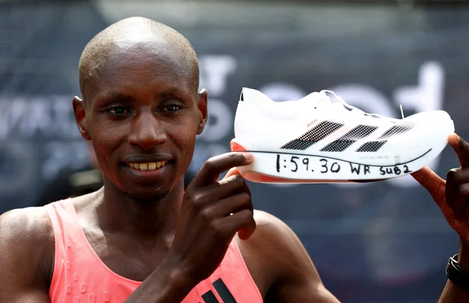 Morda večina najprej opazi, da je na rob podplata s črnim flomastrom zapisal rekordni dosežek – 1:59:30. Toda bolj kot na številke hoče Sabastian Sawe pokazati, da gre za Adidasov športni copat. FOTO: Matthew Childs/Reuters