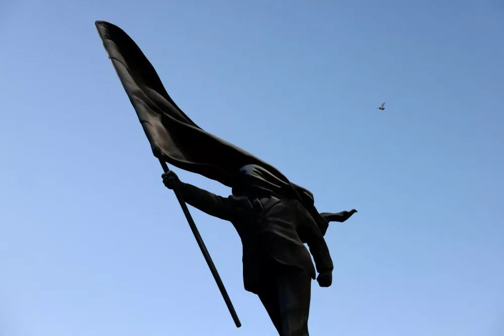 A statue depicting a person stepping off the plinth while carrying a flag covering their face, by British street artist Banksy, stands in London, Britain, April 30, 2026. REUTERS/Jack Taylor