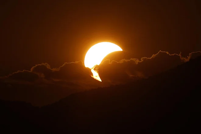 Delni sončni mrk, kot je bil viden iz Ljubljane malo pred pol osmo uro zvečer. FOTO: Leon Vidic