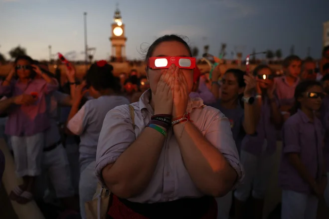 Sončni mrk iz morskega pristanišča Tarragona v severovzhodni Španiji. FOTO: Josep Lago/AFP