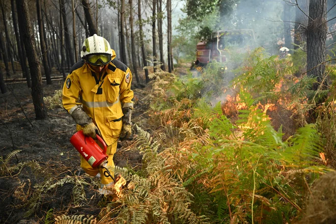 Gasilci z načrtovanimi požigi omejujejo požar na jugozahodu Francije. FOTO: Gaizka Iroz/AFP
